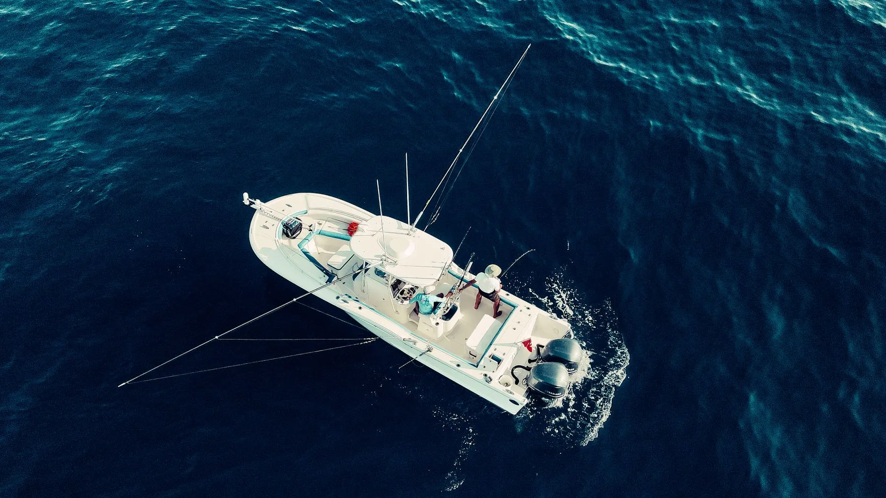 An aerial view of a fishing boat on deep blue water