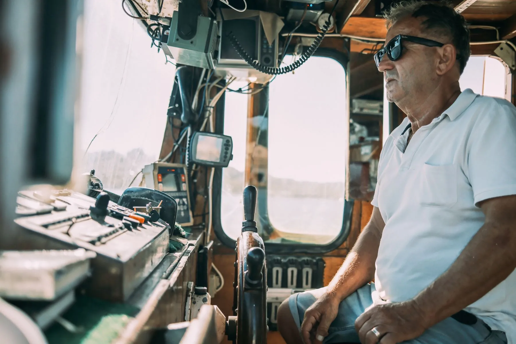 A charter captain at the helm with the navigation screens beside him