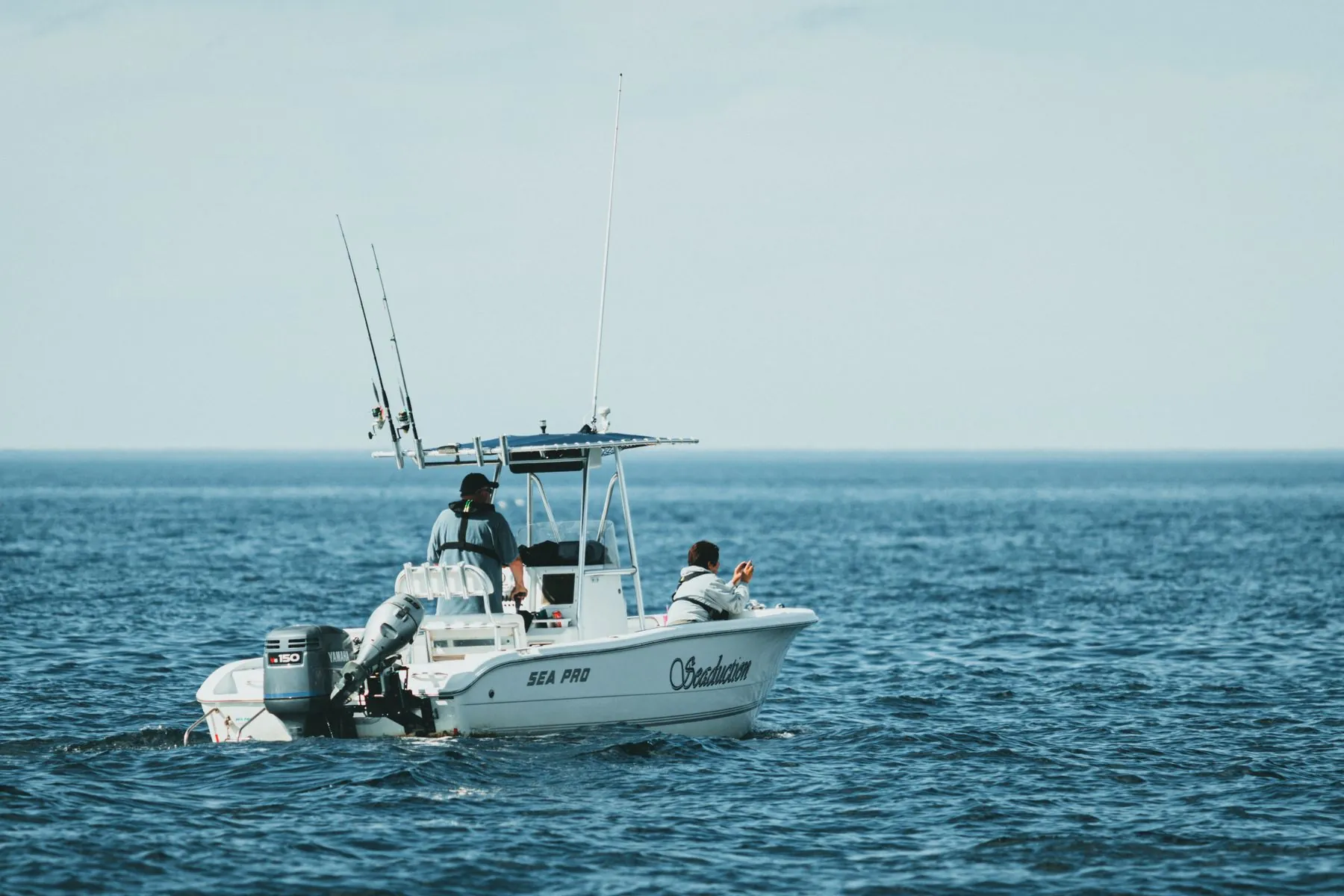 A center-console charter fishing boat underway with anglers aboard