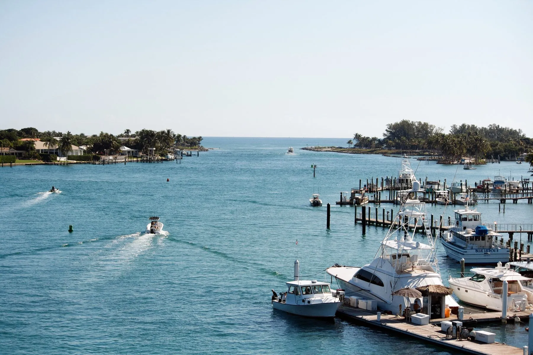 Charter and sport boats running an inlet past a marina in Florida