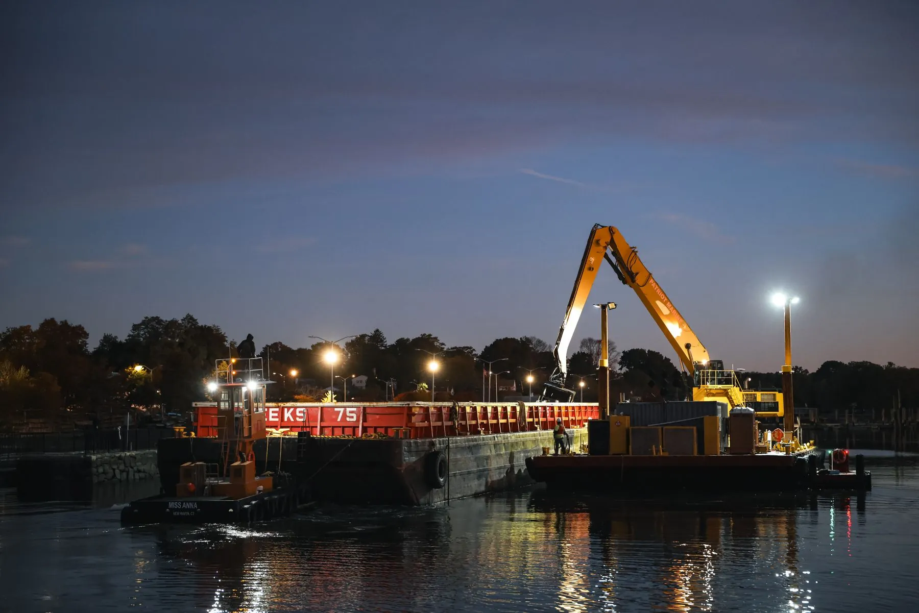 A dredge working at a marina in Connecticut at dusk