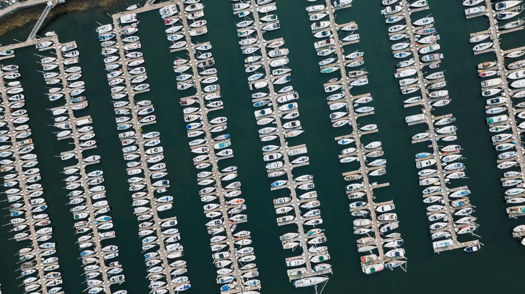 An aerial view of a large marina in Seattle with rows of boats in their slips